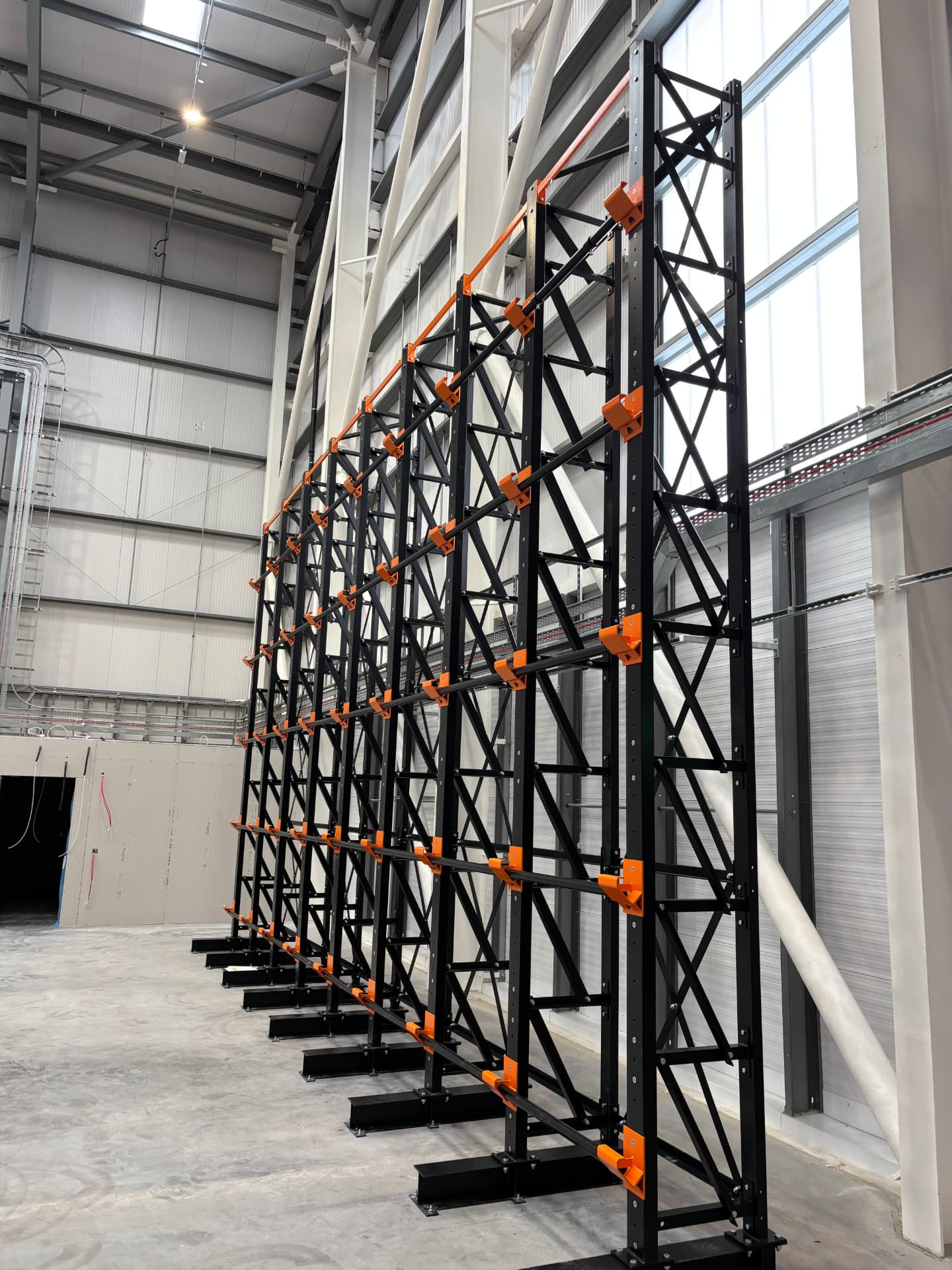 Run of black coil racking with orange cradles in Demesne Electrical's warehouse